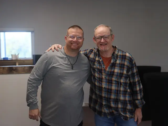 Two men from the church smiling with their arms around each other